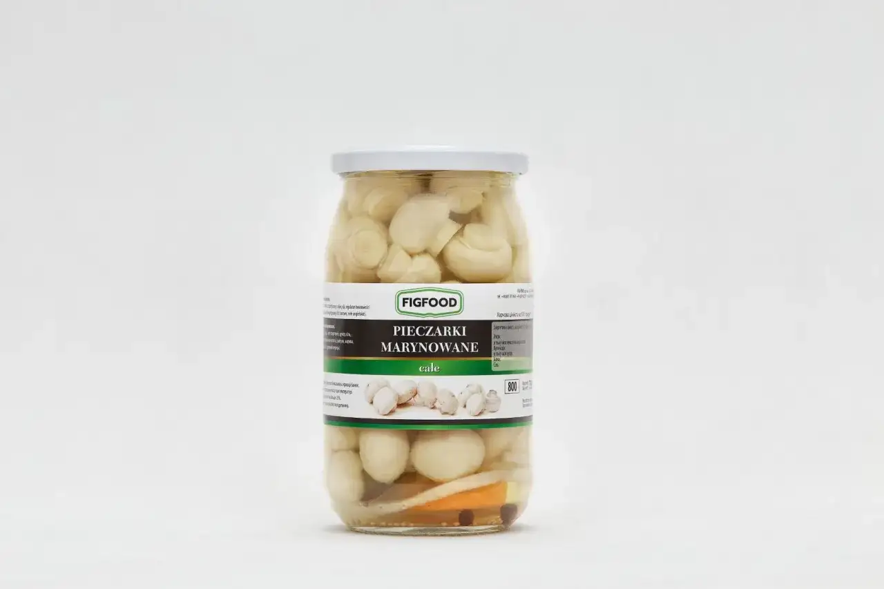 Słoik z marynowanymi pieczarkami marki Figfood, z widocznymi kawałkami warzyw i przypraw.
